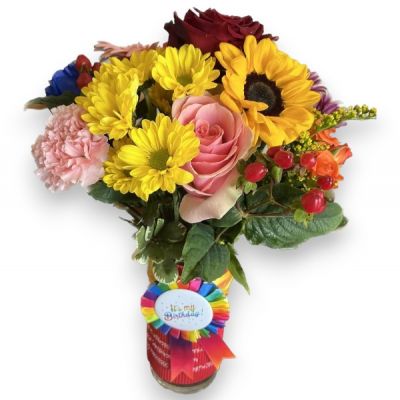 A mixture of Beautiful colorful Bright Seasonal Flowers arranged in hand Decorated Vase with Pin Button.